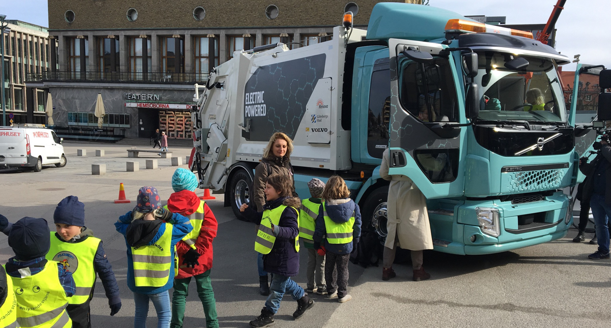 Nyfikna förskolebarn vid den elektriska sopbilen.