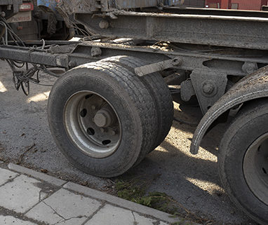 En släpvagn som saknar två stänkskärmar används för timmertransporter till Holmens bruk i Hallstavik.