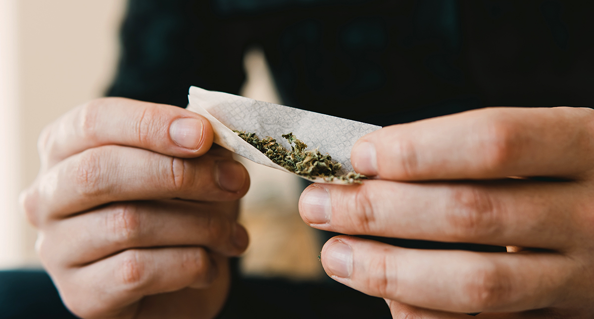 En man rullar en marijuana cannabis-joint.