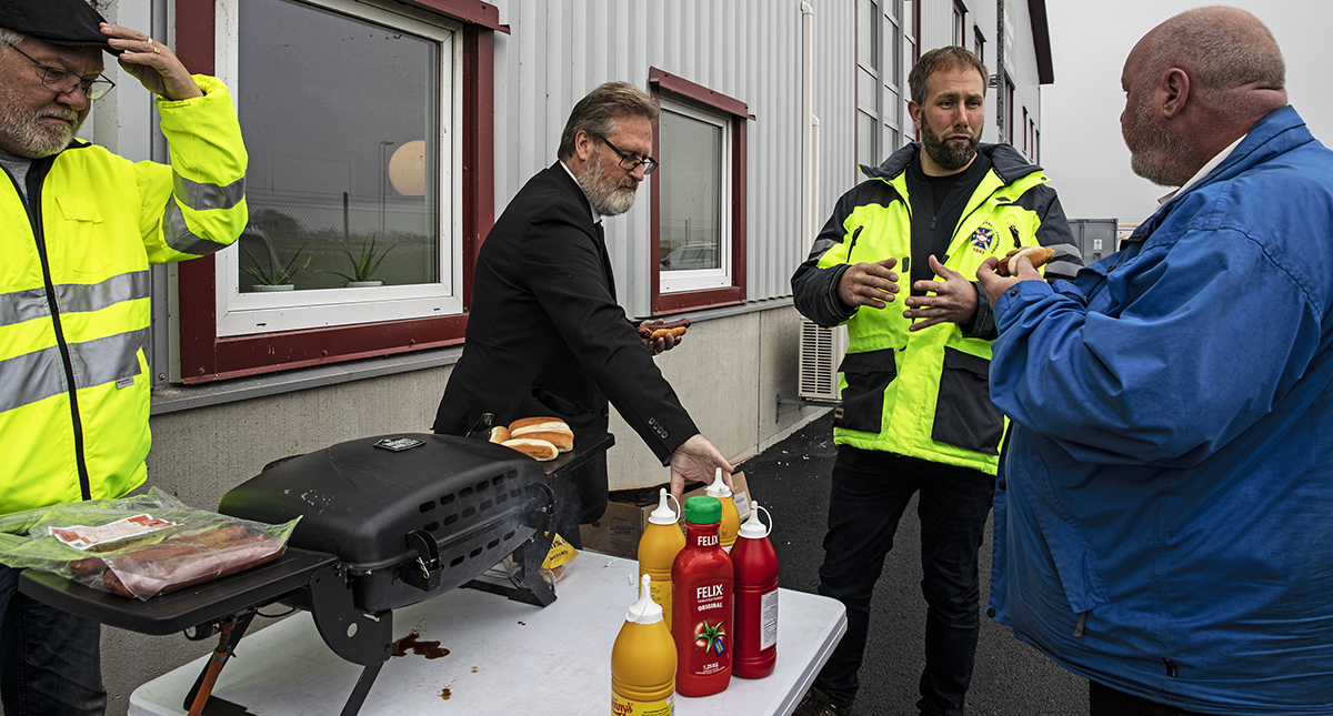 Peter Lundström (till vänster) från Malmöavdelningen hanterar grillen medan varselklädda taxiuppsökaren Jon Wall diskuterar överetablering och fusk i branschen med åkare och chaufförer.