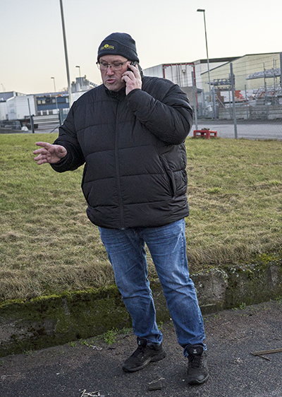 Logistik efter arbetstid: Peter talar i mobilen om morgondagens körning för en av chaufförerna som ska återgå till arbetet efter sjukdom. Foto: Lilly Hallberg