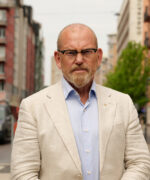 Skallig man med skägg och ljus kostym på en innerstadsgata i Stockholm