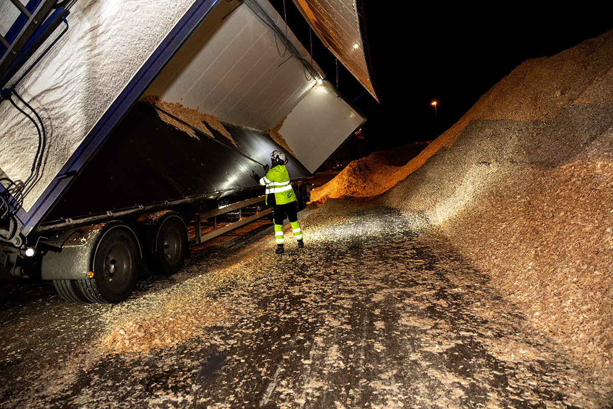 Lossning vid Skoghalls bruk. Mimmi Broström tippar släpet och skrapar ut den sista flisen med en skrapa. Foto: Justina Öster