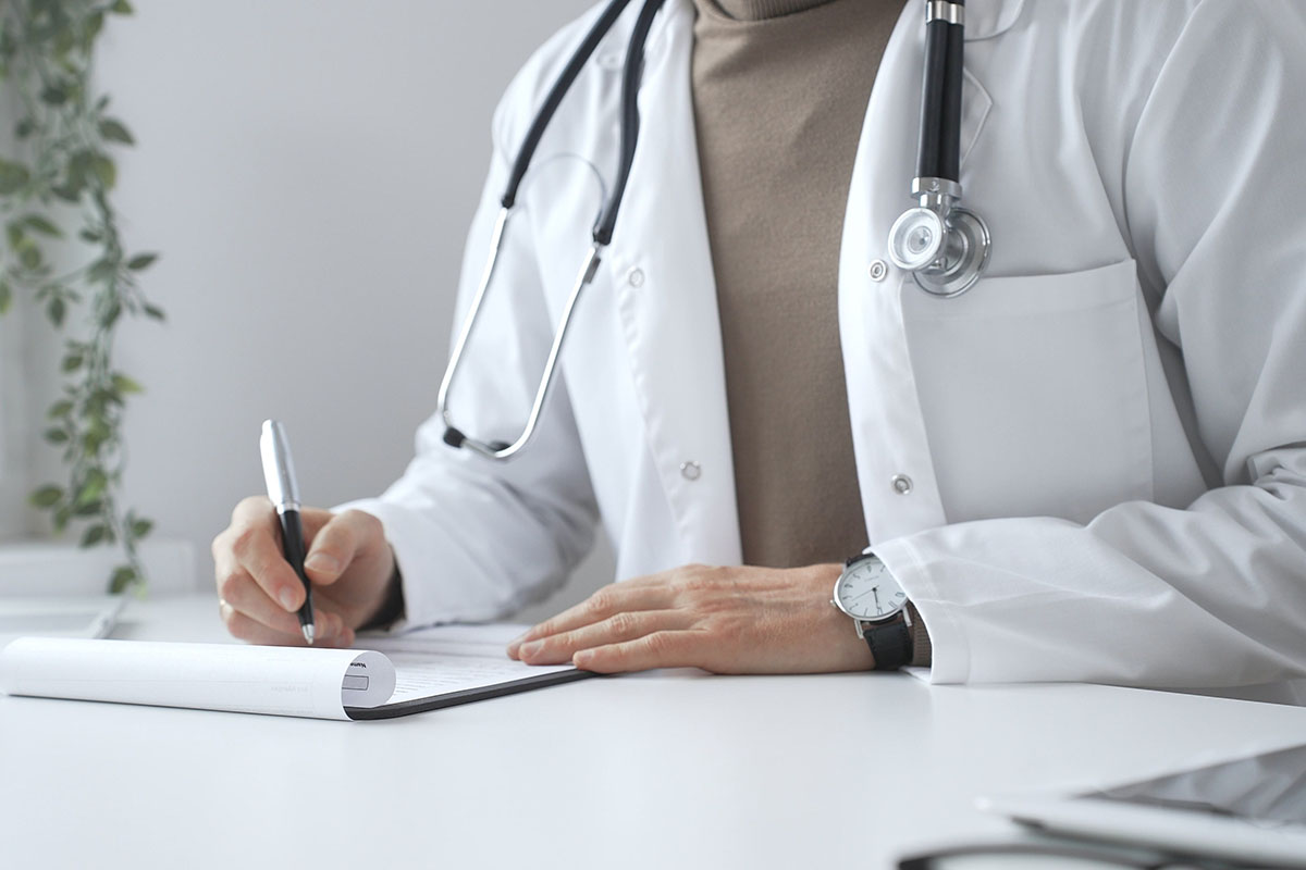 Läkarrock med stetoskop. Läkaren skriver för ett läkarintyg.