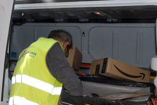 En man i gul varselväst packar paket.